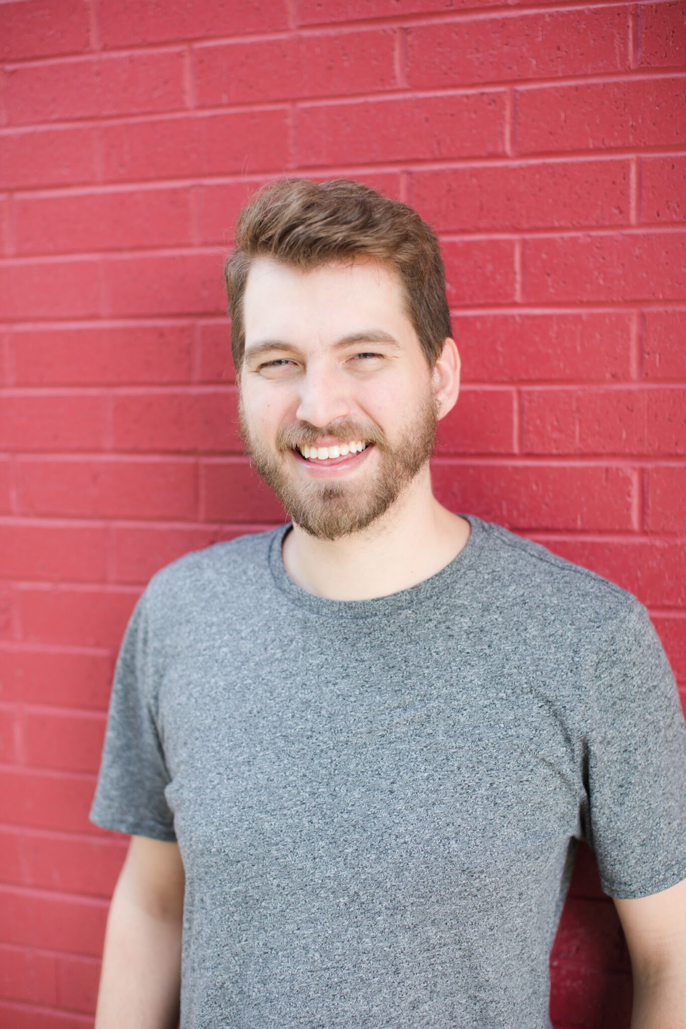 Headshot of Zach Weyland in front of a red brick wall, casual and approachable.
